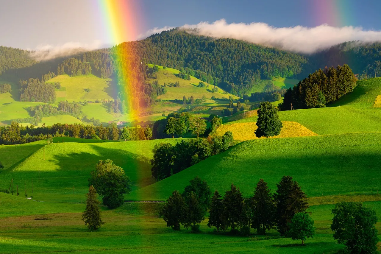Regenbogen über grünen Hügeln